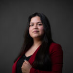 Professional corporate headshot of a Calgary businesswoman wearing a cherry red blazer