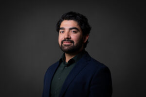 Professional corporate headshot of a Calgary businessman wearing a blue jacket and green dress shirt